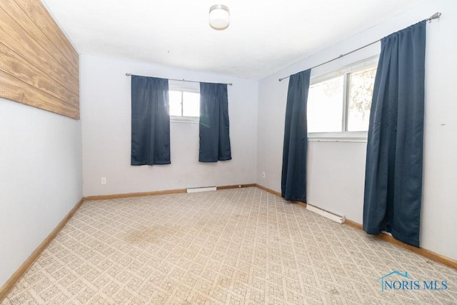 empty room featuring carpet and baseboard heating