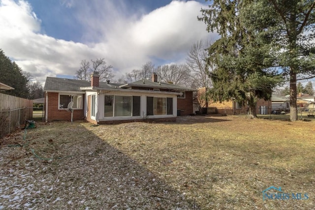 back of house featuring a lawn