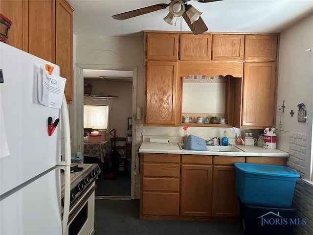 kitchen featuring ceiling fan, sink, white refrigerator, and gas stove