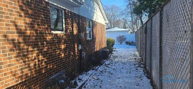 view of snow covered exterior with cooling unit