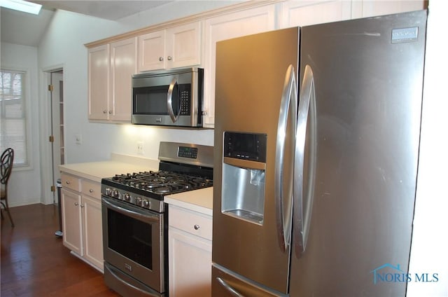 kitchen with appliances with stainless steel finishes and dark hardwood / wood-style flooring