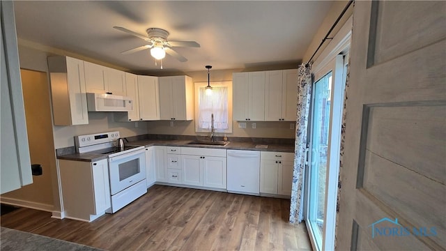 kitchen featuring decorative light fixtures, wood-type flooring, sink, white cabinets, and white appliances