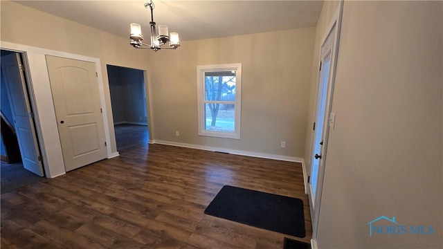 unfurnished dining area with dark hardwood / wood-style floors and an inviting chandelier