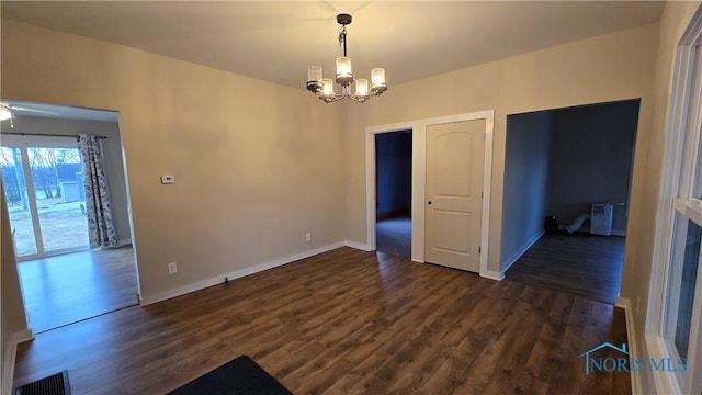 unfurnished dining area with dark hardwood / wood-style flooring and ceiling fan with notable chandelier