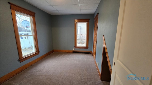 unfurnished room featuring carpet flooring and a drop ceiling