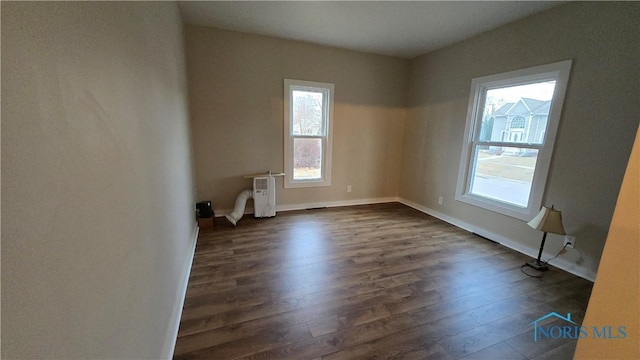 empty room with radiator and dark hardwood / wood-style flooring