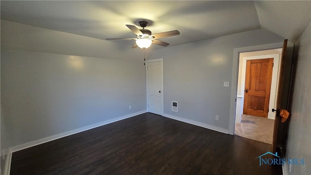 unfurnished bedroom featuring lofted ceiling, dark wood-type flooring, and ceiling fan