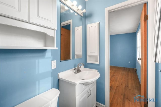 bathroom with vanity, wood-type flooring, and toilet