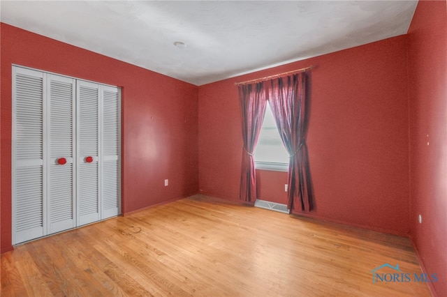 unfurnished bedroom featuring light hardwood / wood-style floors and a closet