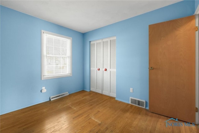 unfurnished bedroom featuring light hardwood / wood-style floors and a closet