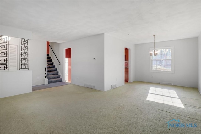 unfurnished room with light colored carpet and a chandelier