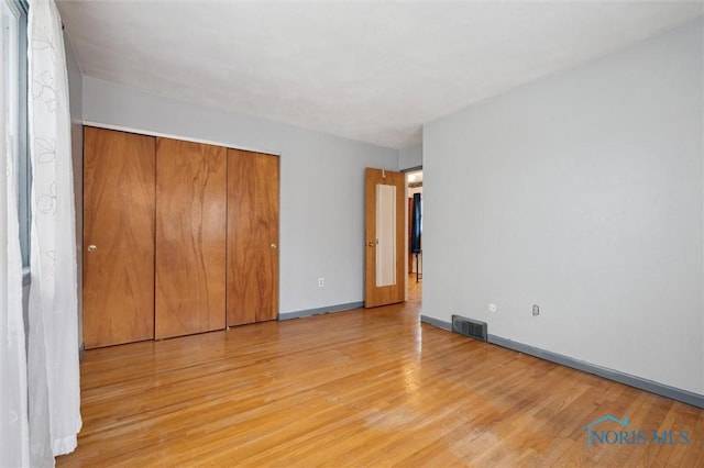 unfurnished bedroom featuring a closet and light hardwood / wood-style flooring