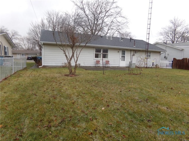 rear view of house with a patio and a lawn