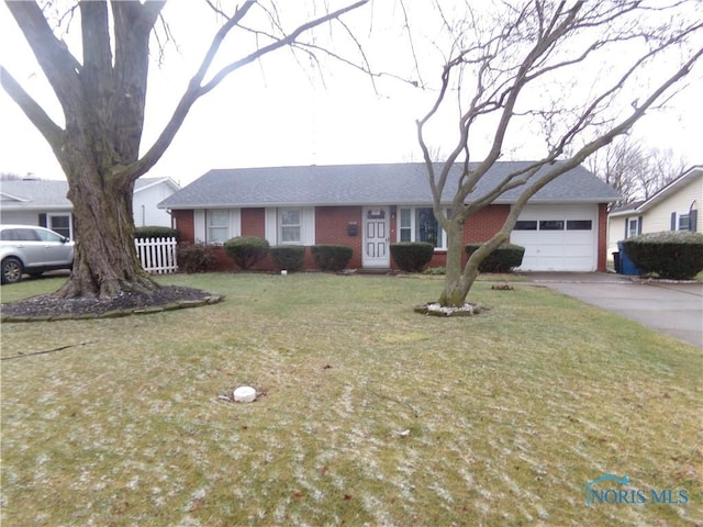 single story home with a garage and a front lawn