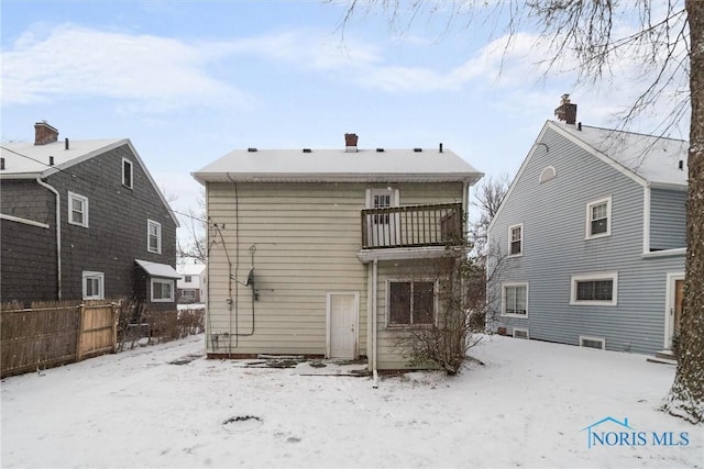 snow covered property with a balcony