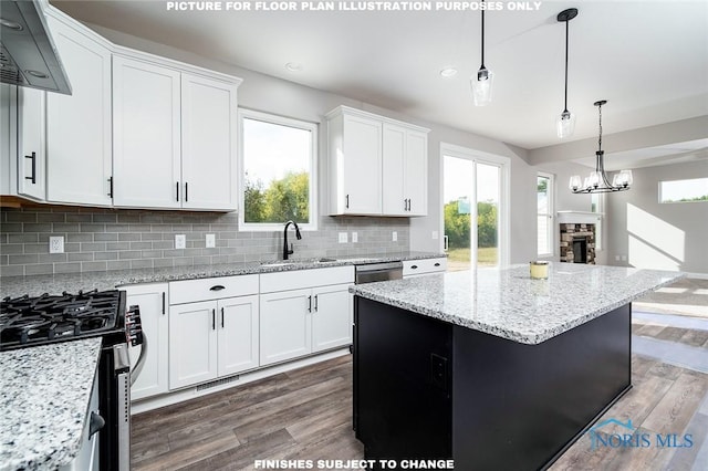 kitchen featuring white cabinets, dark wood-type flooring, a stone fireplace, and a kitchen island