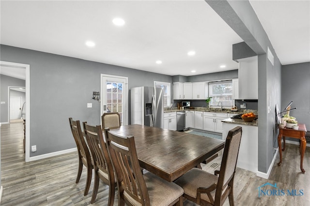 dining space with light wood-type flooring and sink