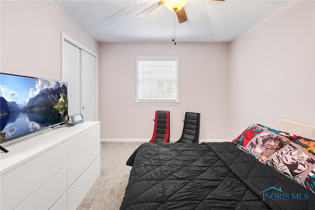 bedroom with ceiling fan, light colored carpet, and a closet