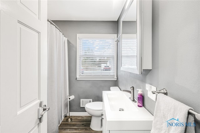 bathroom featuring hardwood / wood-style flooring, toilet, and vanity