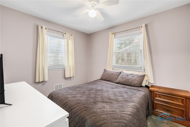 bedroom with ceiling fan, multiple windows, and carpet