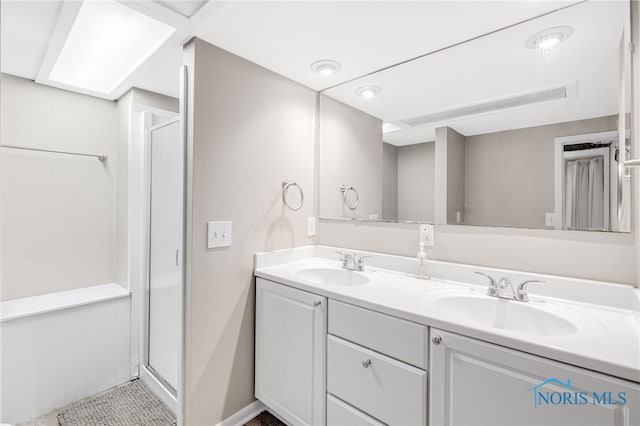 bathroom with a shower with door, tile patterned floors, and vanity