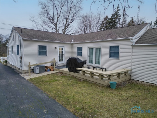 back of property featuring a lawn, cooling unit, and a deck