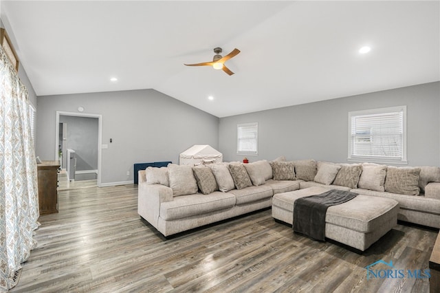 living room featuring ceiling fan, vaulted ceiling, a wealth of natural light, and hardwood / wood-style flooring