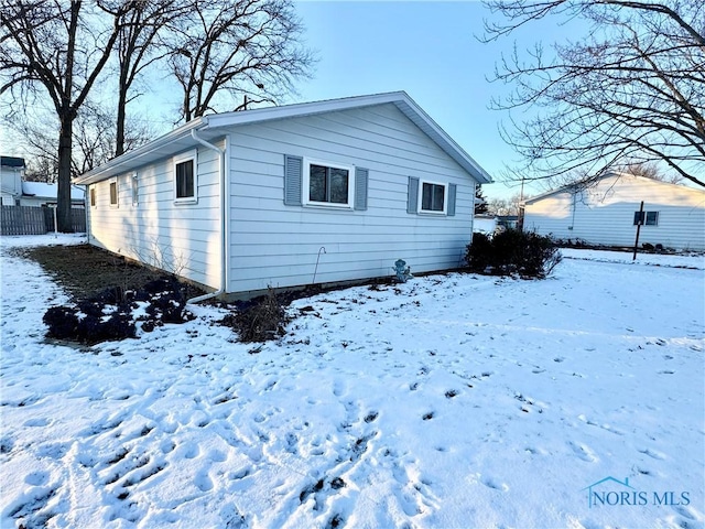 view of snow covered back of property