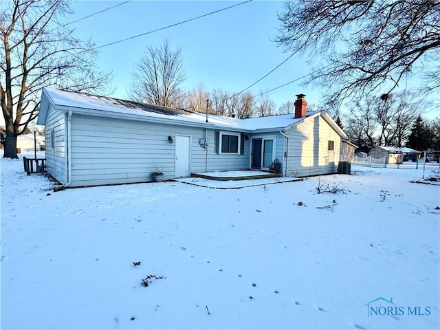 view of snow covered back of property