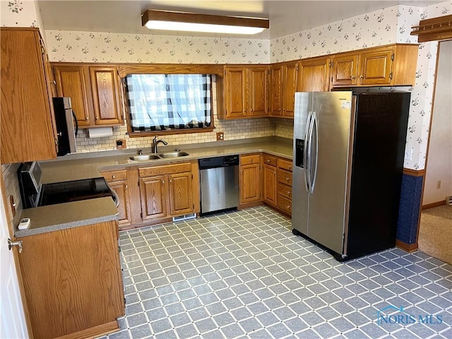 kitchen with tasteful backsplash, appliances with stainless steel finishes, and sink