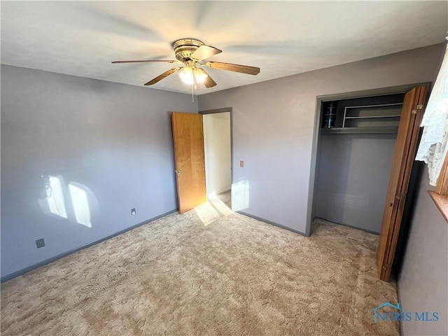 unfurnished bedroom featuring ceiling fan, a closet, and carpet flooring