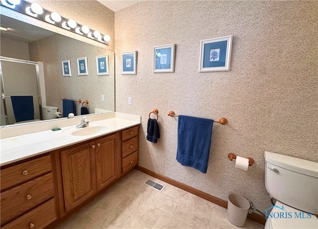 bathroom with vanity, a shower with shower door, and toilet