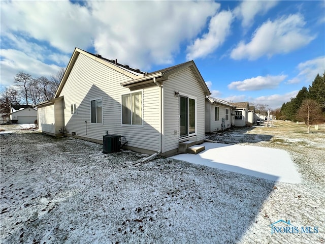 view of snow covered exterior featuring central AC unit and a patio