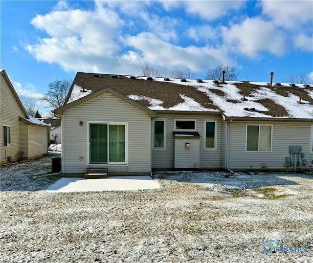 snow covered property with a patio