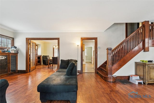 living room featuring wood-type flooring, french doors, and ornamental molding