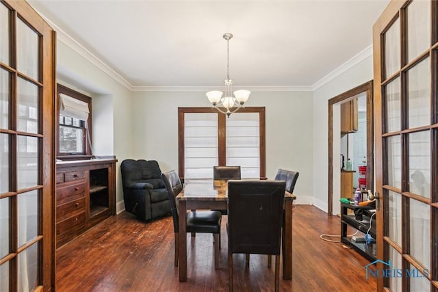 dining room with dark hardwood / wood-style floors, crown molding, french doors, and an inviting chandelier