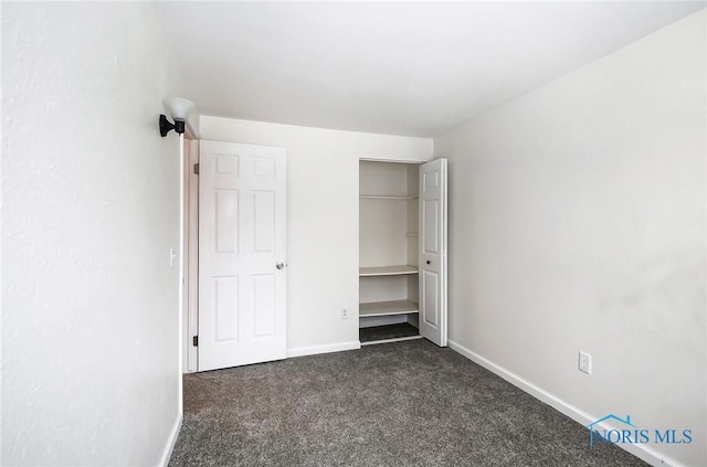 unfurnished bedroom with dark carpet