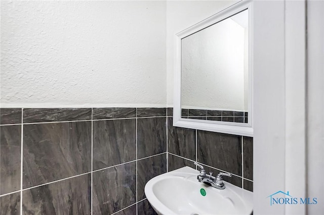 bathroom with tile walls and sink