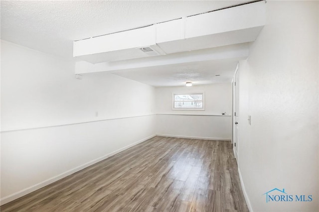 basement with a textured ceiling and hardwood / wood-style flooring