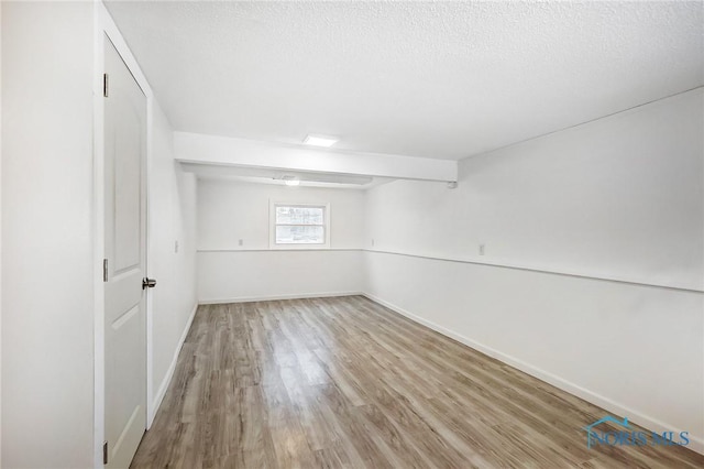 basement featuring a textured ceiling and hardwood / wood-style floors