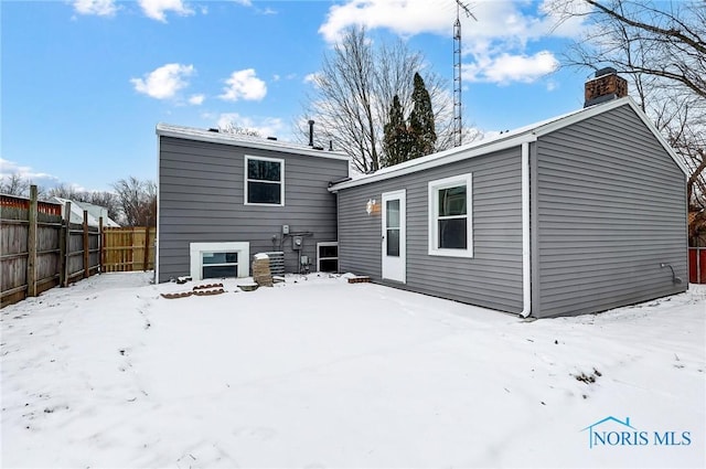 view of snow covered rear of property