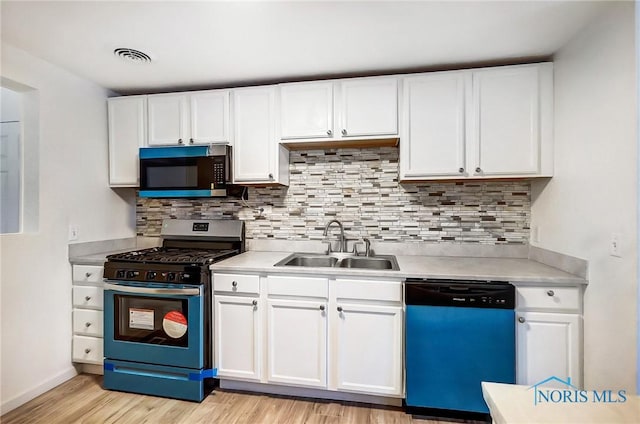 kitchen with light hardwood / wood-style floors, stainless steel appliances, tasteful backsplash, white cabinets, and sink