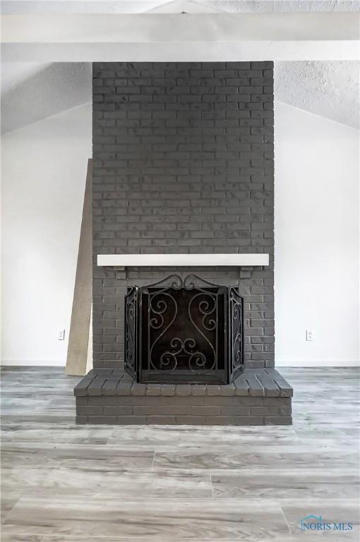 details featuring a fireplace, a textured ceiling, and hardwood / wood-style flooring