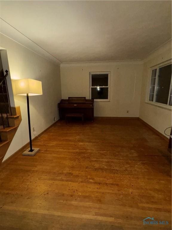 empty room with hardwood / wood-style flooring and ornamental molding