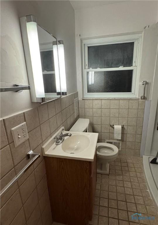 bathroom with vanity, tile walls, tile patterned floors, and toilet