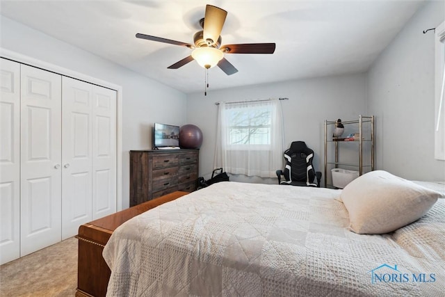 carpeted bedroom with ceiling fan and a closet