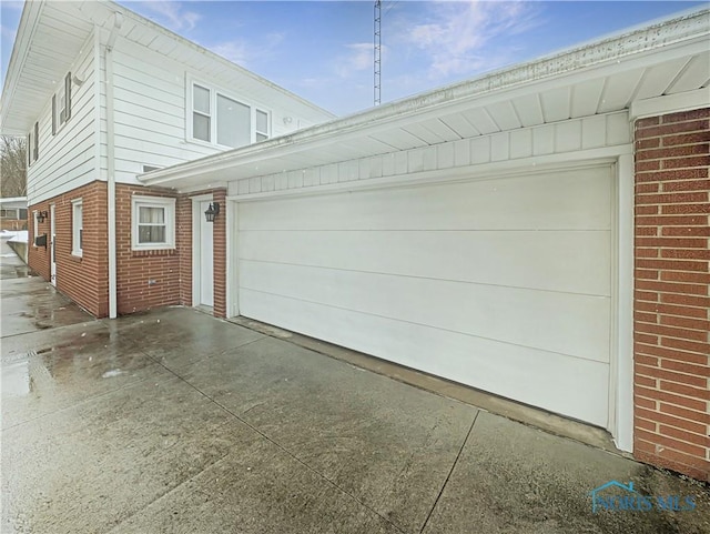1318 E 4th St, Marblehead, OH 43440 - view of side of property featuring brick siding, driveway, and a garage
