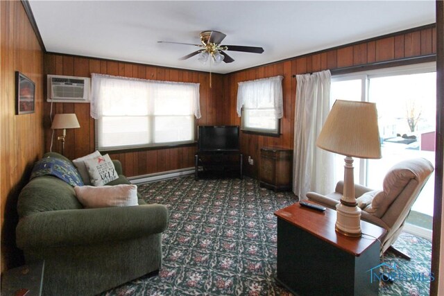 1318 E 4th St, Marblehead, OH 43440 - living room with ceiling fan, a wall mounted AC, baseboard heating, wooden walls, and dark carpet