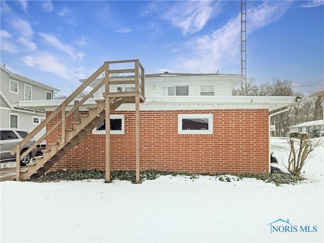 1318 E 4th St, Marblehead, OH 43440 - snow covered house featuring brick siding and stairs