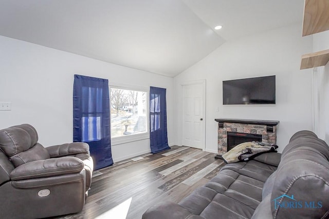 living room with vaulted ceiling, wood-type flooring, and a fireplace